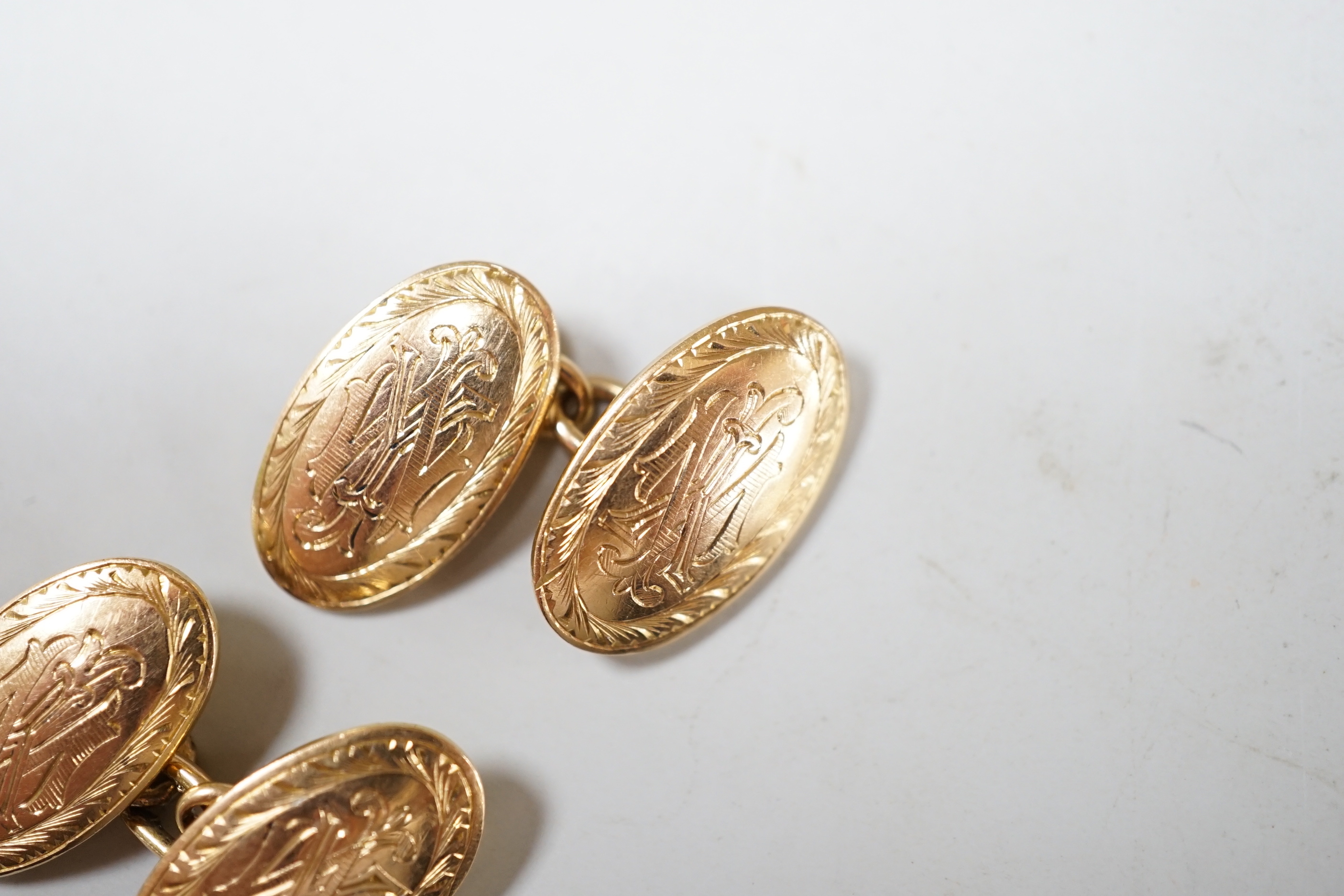 A pair of Edwardian engraved 15ct gold oval cufflinks, 10 grams.